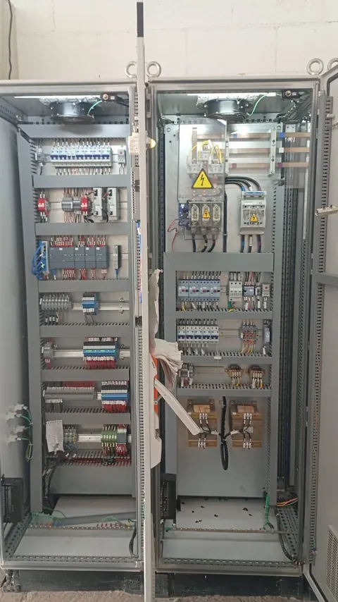 Detalhe de componentes, canaletas e circuitos internos de um painel elétrico.