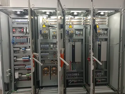 Conjunto de painéis elétricos abertos com dispositivos de comando e acionamento.