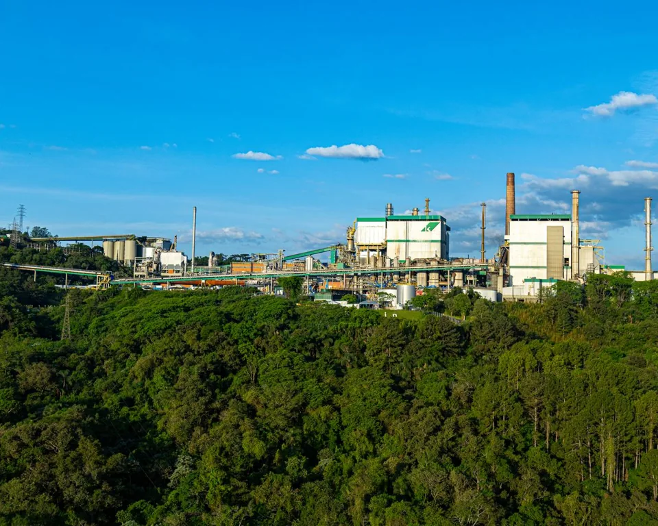 Instalação industrial em Telêmaco Borba, no Paraná, cercada por vegetação.