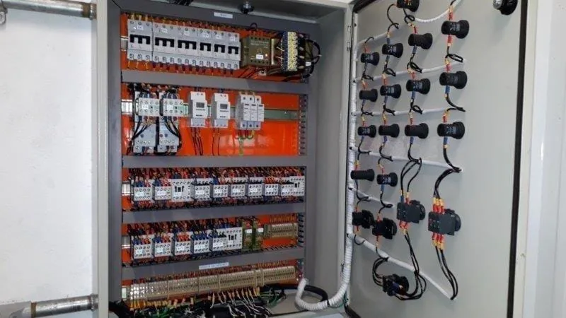 Painel aberto com disjuntores, contatores, bornes e comandos instalados na porta.