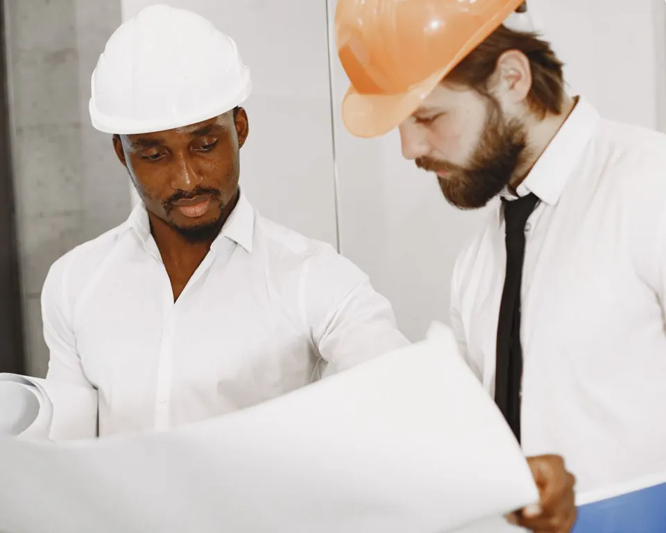 Profissionais analisando plantas de um projeto de engenharia.
